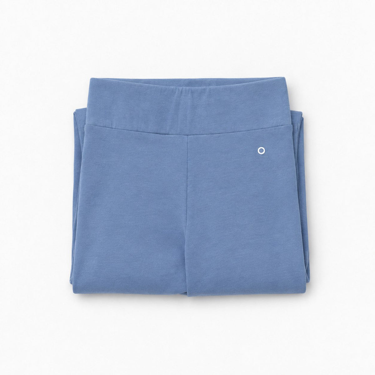 A pair of folded dusty blue organic cotton high waist leggings with a wide elastic waistband and a small white circular logo on the upper right leg, shown on a clean white background.