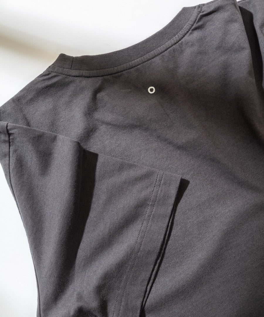 Close-up of a dark gray shirt with a button on a white background