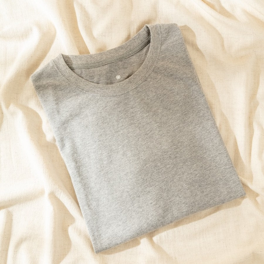Folded gray t-shirt on a beige fabric background