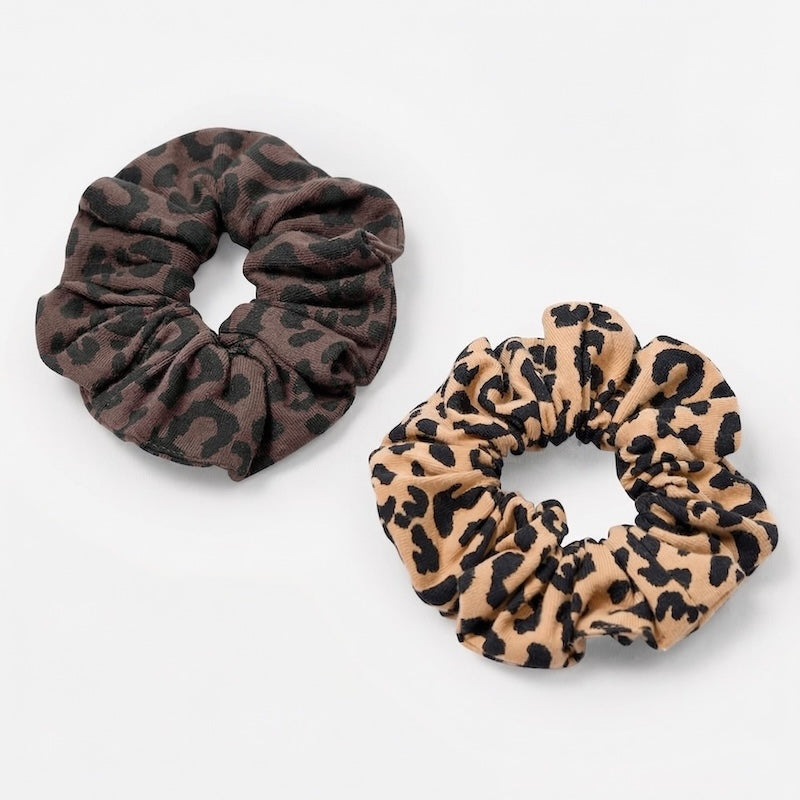 Two leopard print scrunchies on a white background