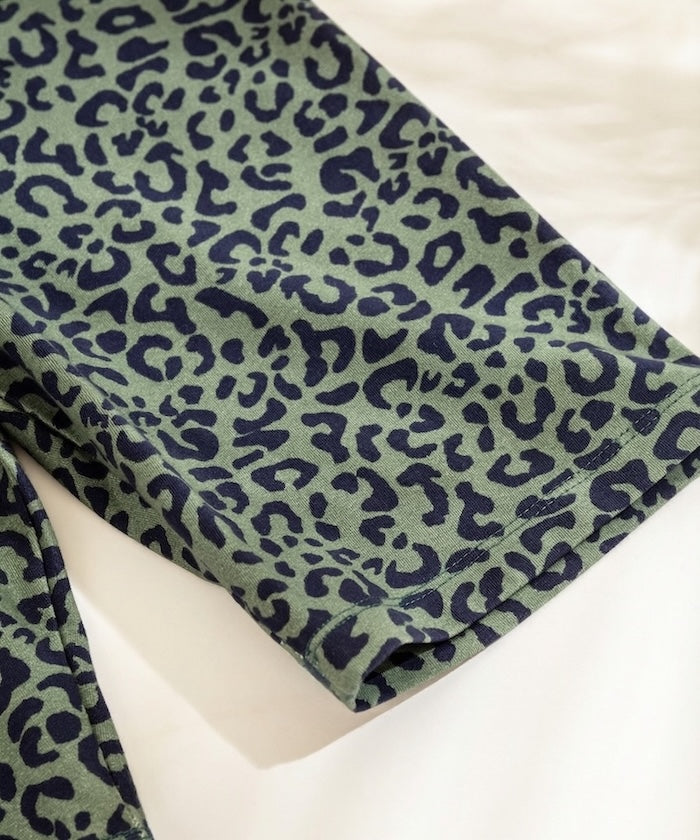 Green fabric with black leopard print pattern on a white background
