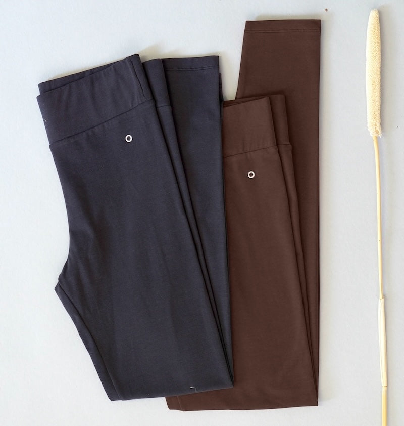 Two pairs of pants, one black and one brown, on a white background.