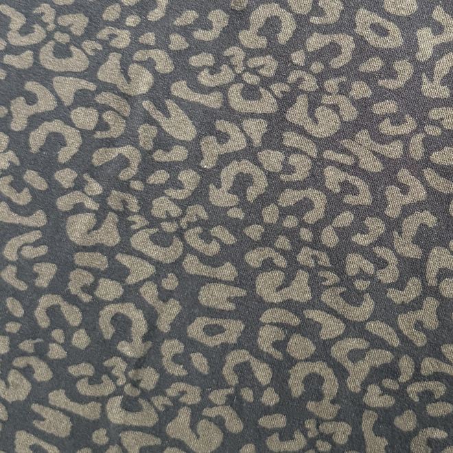 A close-up of a leopard print fabric or wallpaper pattern featuring beige spots on a dark charcoal gray background.