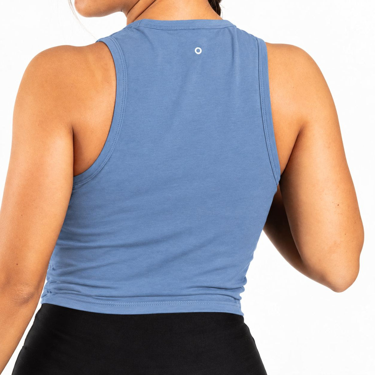 Back view of a woman wearing a sleeveless blue Organic Cotton Tank Top with built in bra  and black bottoms against a plain white background.